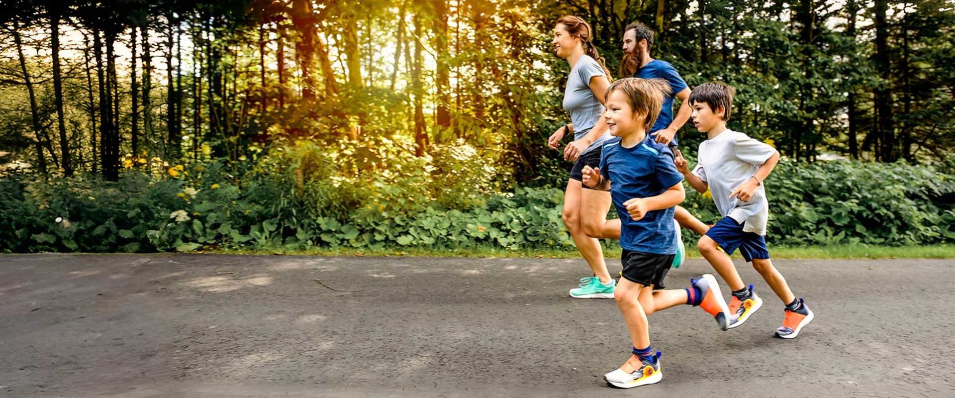 Family running together on a tree-lined road